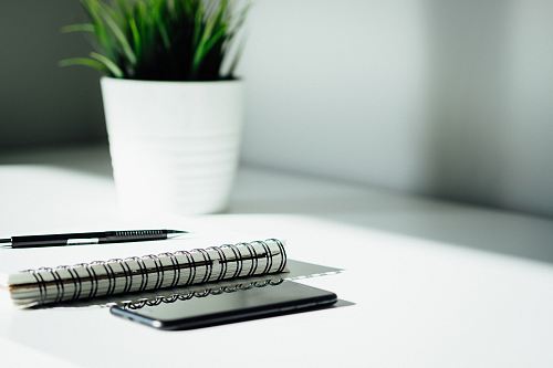 pen, notebook, and smartphone on table