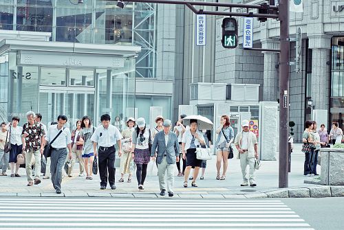 people crossing pedestrian lane near building at daytime