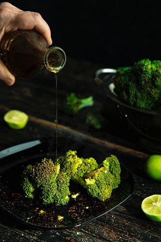 person pouring cola on broccoli