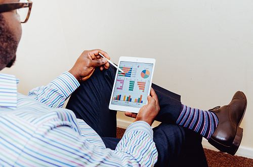 person sitting on chair holding iPad
