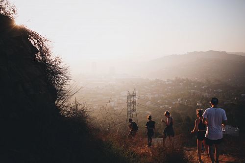 photo of five people walking down on pathway