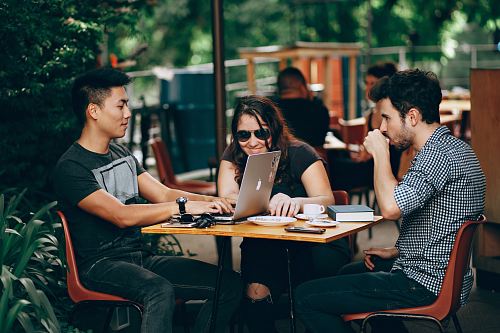 photo of three person sitting and talking