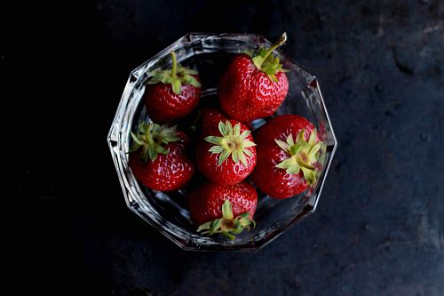 red strawberries in clear glass bowl