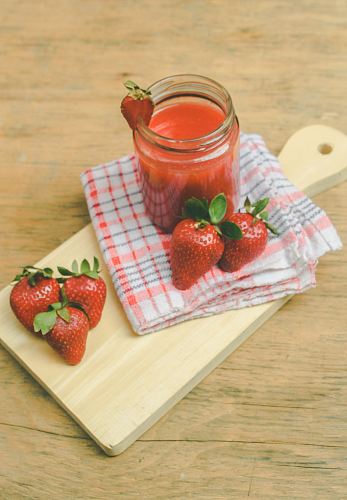 red strawberries on brown chopping board