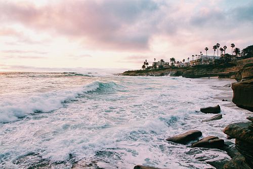 sea waves crashing on shore during golden hour