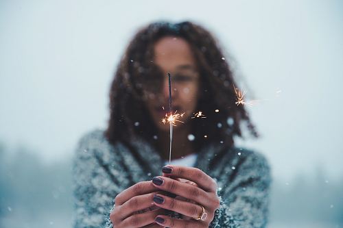 selective focus photography of person holding lighted sparkler