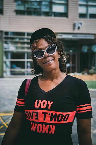 selective focus photography of woman wearing black V-neck shirt near building at daytime