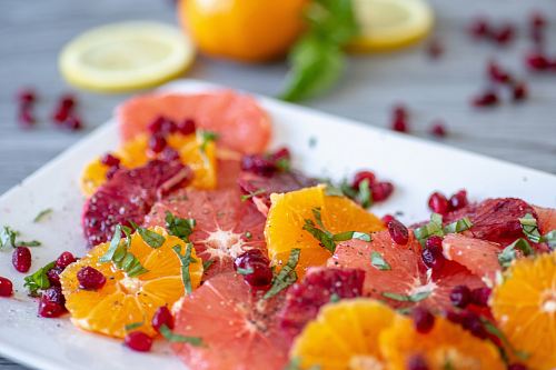 shallow focus photo of sliced fruits on white ceramic tray