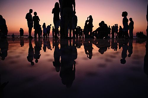 silhouette of people standing on mirror during golden hour