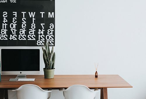 silver iMac on brown wooden desk