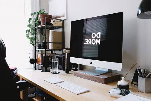 silver iMac with keyboard and trackpad inside room