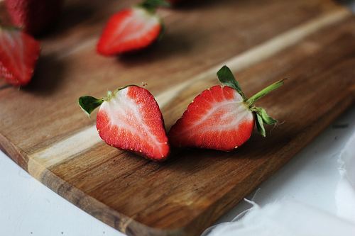 sliced of raspberry on brown wooden board