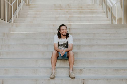 smiling man sitting on staircase