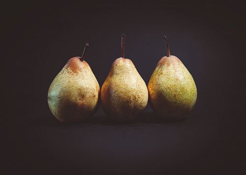 three pears on black surface