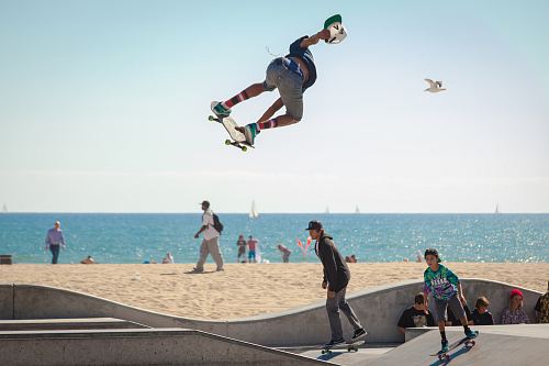 three people playing skateboard beside seashore during daytime