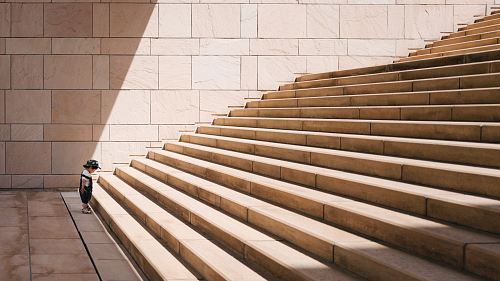 toddler's standing in front of beige concrete stair