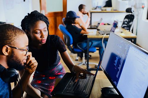 woman and man sitting in front of monitor