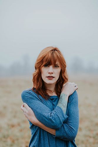 woman in blue raglan shirt shallow focus photography