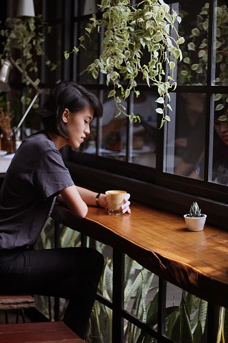 woman sitting on brown wooden chair
