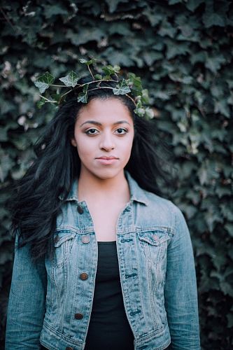 woman standing front of vine plant