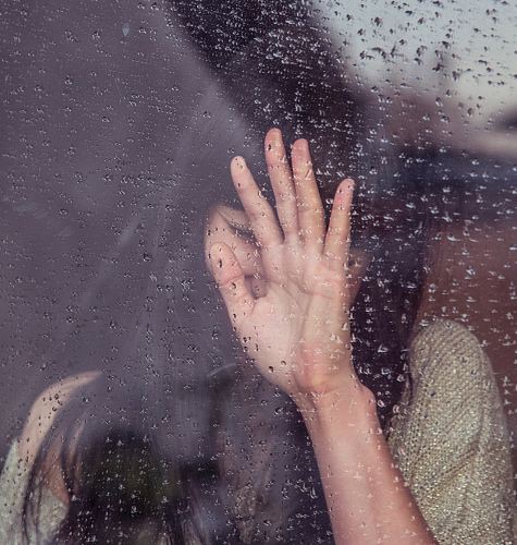 woman touch rainy glass