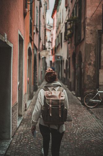 woman walking on street surrounded by buildings