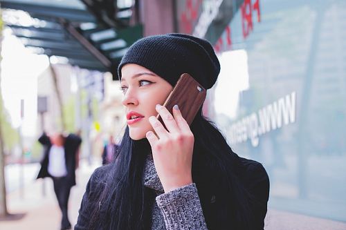 woman wearing beanie with smartphone on ear
