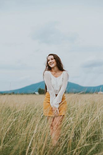 woman wearing brown long-sleeved shirt on green grass field