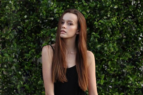 woman wearing spaghetti strap top in front of bush