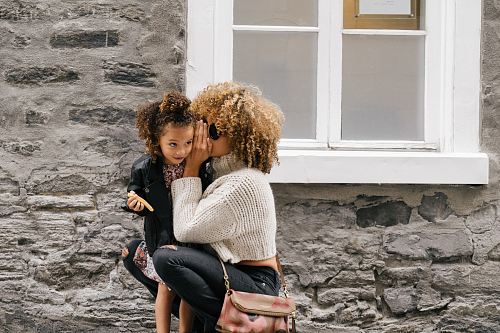 woman wearing white sweater carrying a daughter