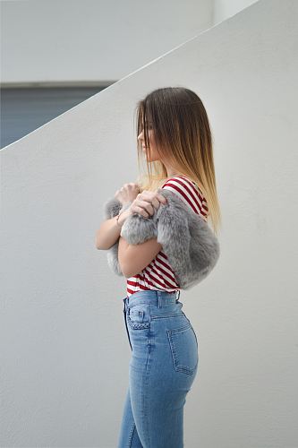 woman with pink fur scarf near wall