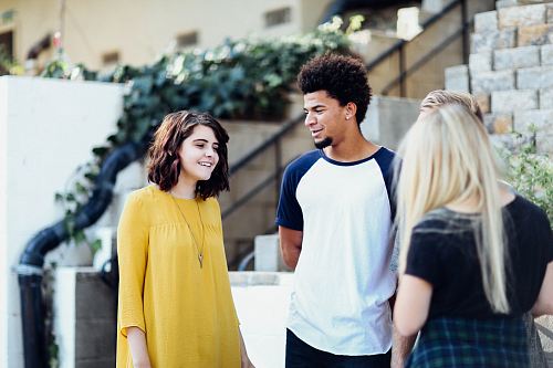 women and man talking outside the building