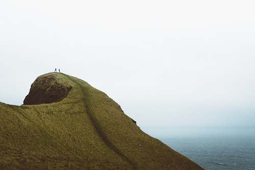  two persons on hilltop during daytime 