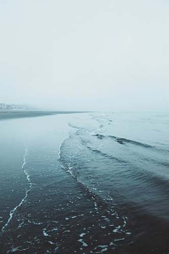 sea seashore under gray sky water