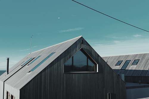 architecture gray wooden house near body of water window