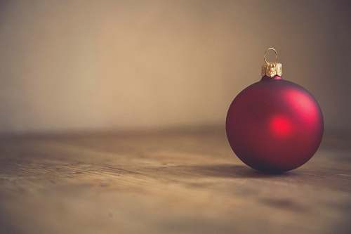 holiday closeup photo of red ball ornament on surface ornament