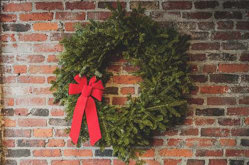 holiday green wreath hang on wall brick brick