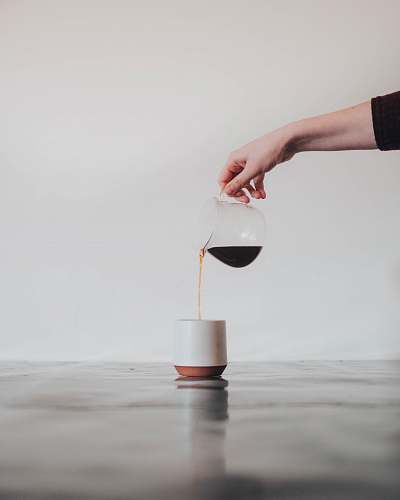 minimal person pouring coffee in white mug minimalist