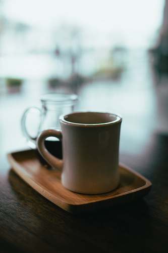 cafe beige mug on top of brown wooden tray coffee cup