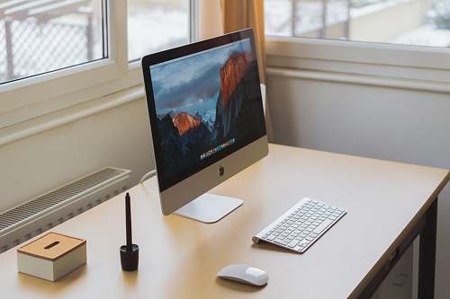 computer turned on silver iMac on table screen