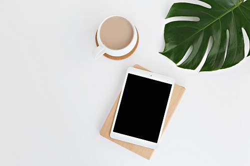cup white iPad on white surface coffee cup