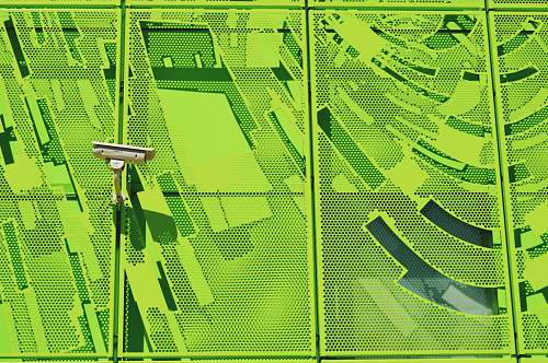 lyon white security camera on green wall france