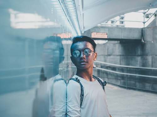 person man in white shirt leaning white wall people