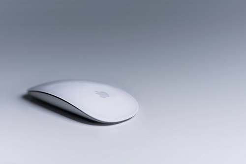 grey Magic Mouse on white surface white