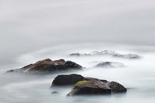 grey time lapse photography of water near island mountain