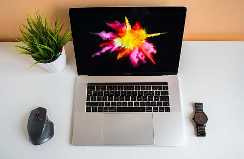 mouse flat lay photography of MacBook Pro in between mouse and watch lcd screen
