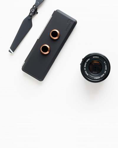 modern closeup photo of black camera attachments on white surface minimal