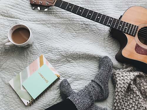 guitar person wearing gray socks near acoustic guitar music