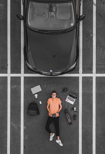 person man lying on parking lot near black car human