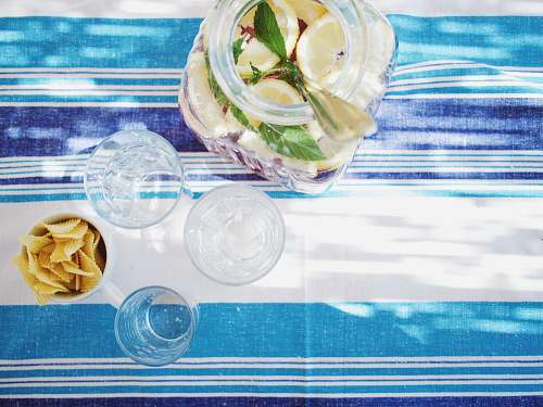 tablecloth lime juice bottle beside shot glasses on table glass